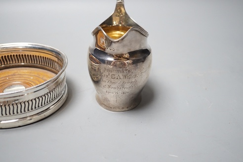 A George III silver mounted wine coaster, Sheffield, 1805, diameter 13.2cm and a George III silver cream jug, with later engraved inscription, London, 1801(a.f.).